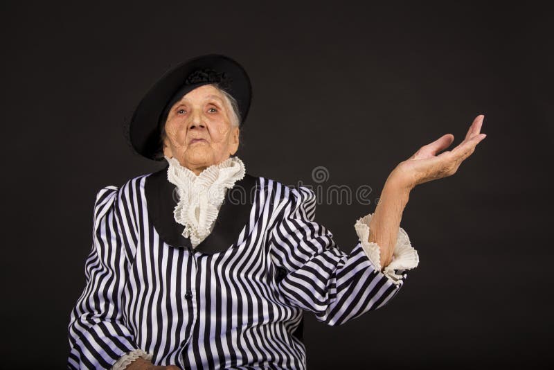 Παλαιό grandma σε ένα άσπρος-μαύρο ριγωτό σακάκι στοκ εικόνες